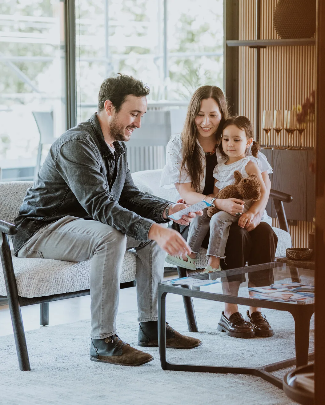 Familia recibiendo asesoría en el living de un departamento piloto